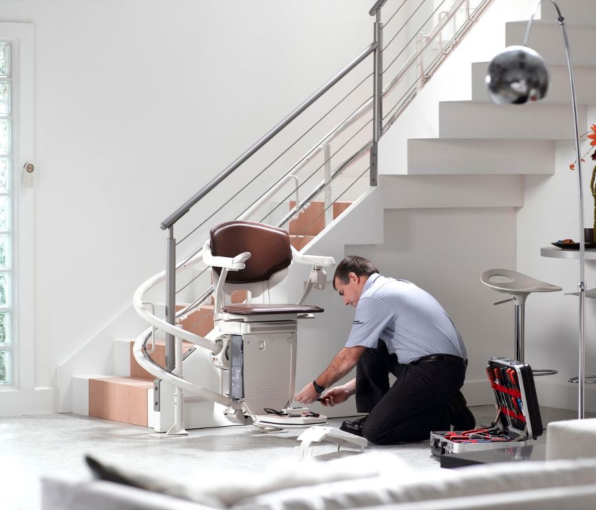 Stannah engineer removing a curved stairlift from a staircase